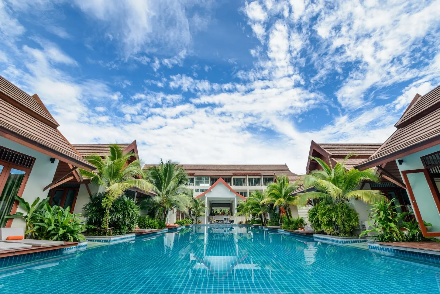Pool im Resort mit Palmen am Abend